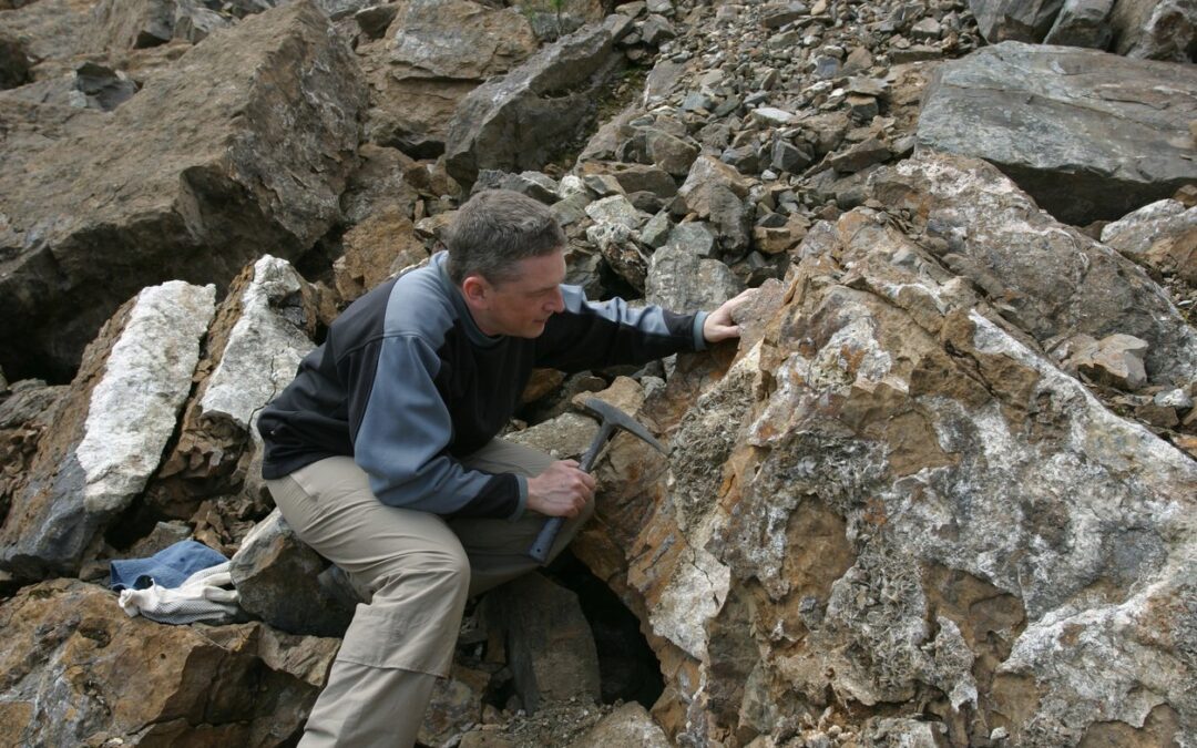Geologist performing mineral exploration of outcroppings
