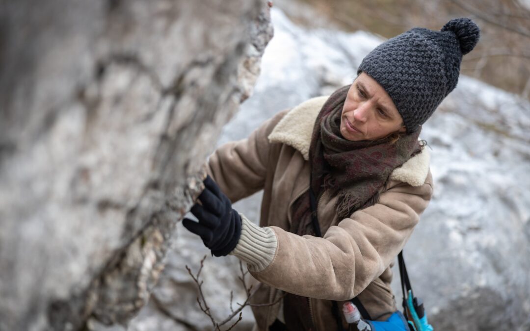 Geologist in winter gear studying outcroppings during mineral exploration