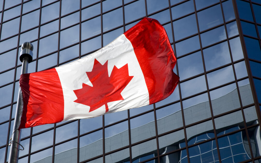 Canadian flag in front of skyscraper to represent regulatory shifts in Canadian geophysics & geotechnical reporting